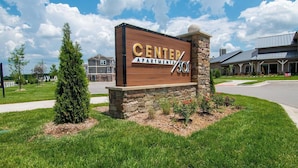 A sign for Center Apartments with a stone base and a wooden top, featuring the number 301. - Landing | Stunning 1BD, Clubhouse, Gym (Belton)