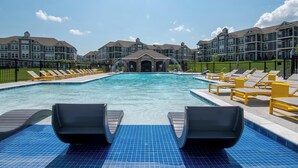 A swimming pool with lounge chairs and a building in the background. - Landing | Stunning 1BD, Clubhouse, Gym (Belton)