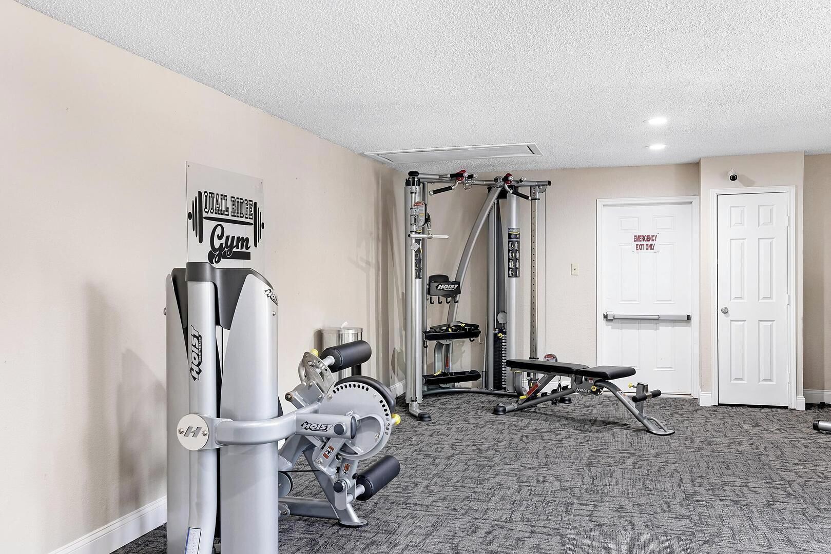 Ein Fitnessraum mit Klimmzugstange, einer Bank und einem Kraftgerät.