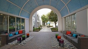 Un patio interior con zonas de estar, suelo de ladrillo y vistas al exterior.