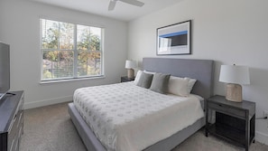 A bedroom with a bed, two bedside tables, a TV, a ceiling fan, and a window with blinds. - Landing | Incredible 2BD, Clubhouse, Pool (Birmingham)