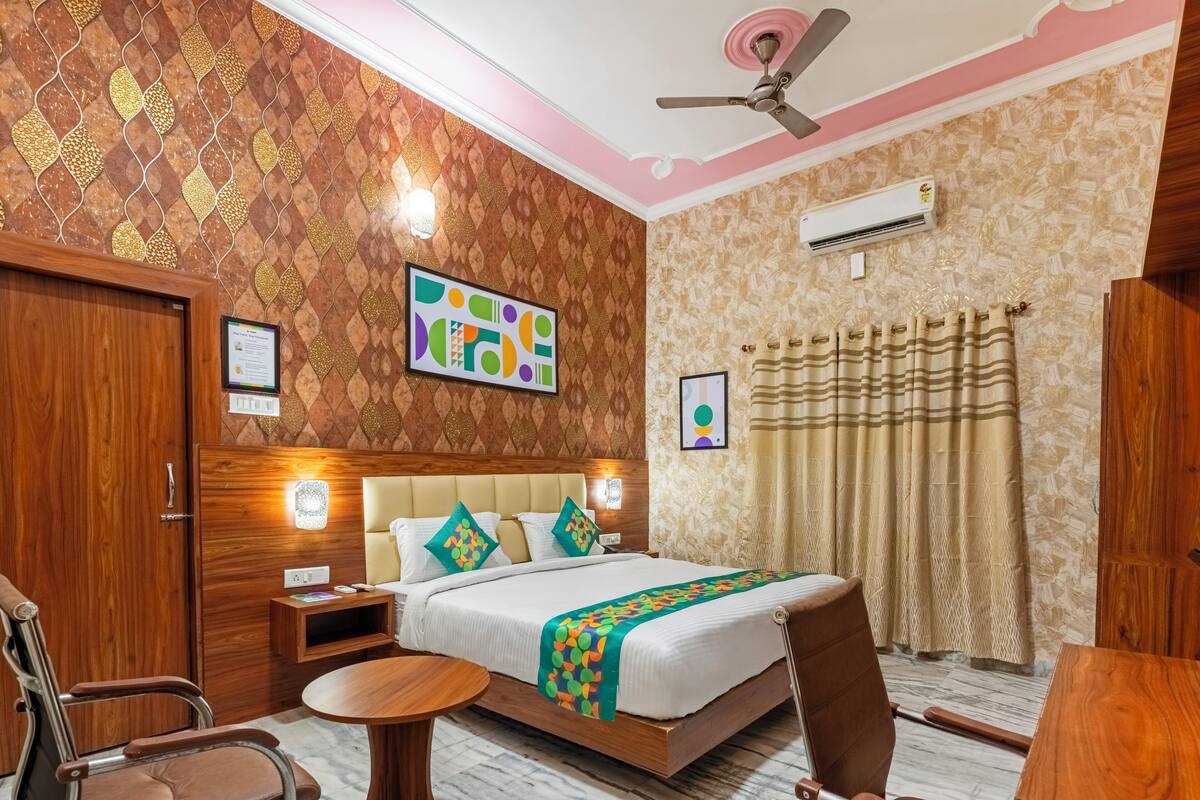 Une chambre à coucher avec un lit, un ventilateur de plafond, un climatiseur et une fenêtre avec des rideaux.