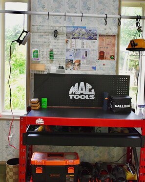 Un banco de trabajo con herramientas y un cartel de pizarra que dice 'MAC TOOLS'.