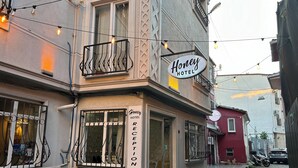 A hotel named "Honey Hotel" with a reception area, air conditioning units, and a balcony with string lights. - Honey Hotel (Istanbul)