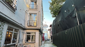 A narrow cobblestone street lined with buildings, including a hotel with a reception sign. - Honey Hotel (Istanbul)