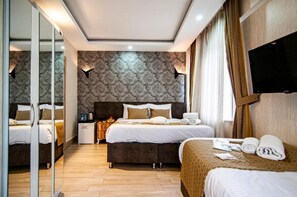 A hotel room with two beds, a flat-screen TV mounted on the wall, a minibar, and a mirror. - Honey Hotel (Istanbul)