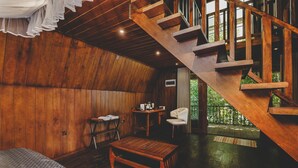 A wooden interior with a staircase, a desk, a chair, and a bed. - River View Villa (Dharga Town)