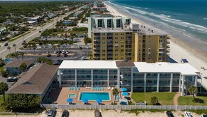 A hotel with a pool, beach view, and multiple floors. - Ocean Front King Suite #215 (New Smyrna Beach)