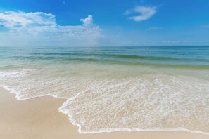 A beach with clear water and a sandy shore.
