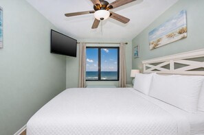 A hotel room with a bed, a ceiling fan, a TV mounted on the wall, and a window with a view of the ocean. - 2 Bedroom Gulf  Front Located in Gulf Shores (Gulf Shores)