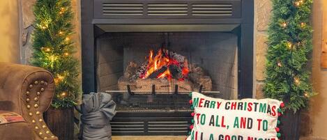 A fireplace with a Christmas tree and a sign that reads "MERRY CHRISTMAS TO ALL, AND TO ALL A GOOD NIGHT".