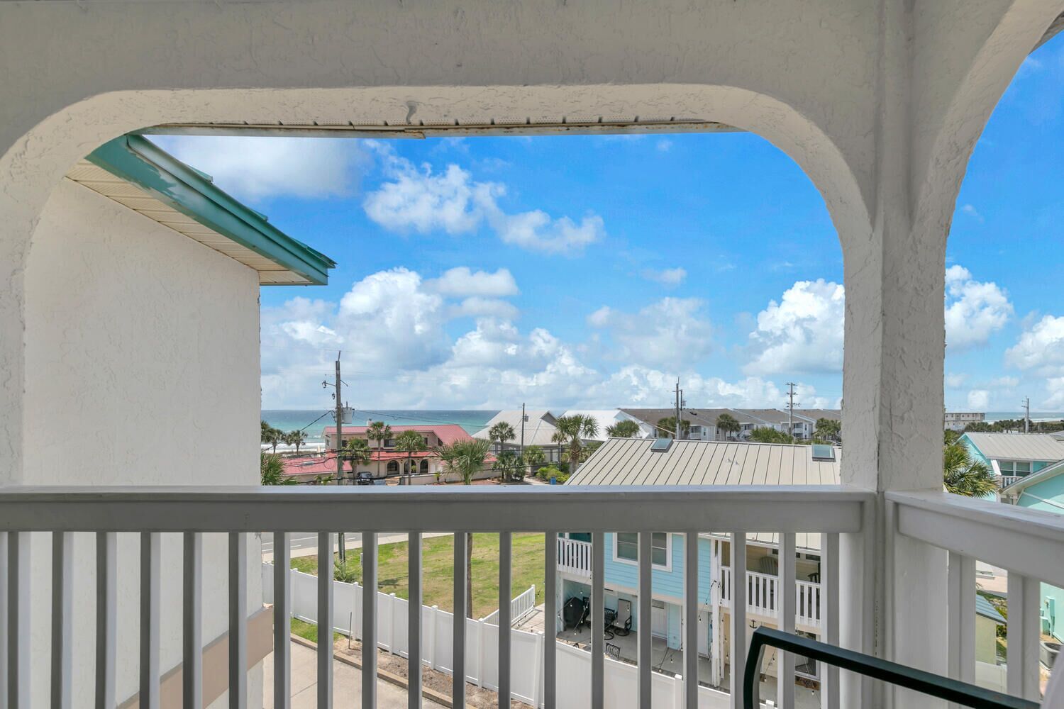 A balcony with a view of the ocean and buildings.