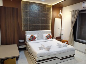 Une chambre d’hôtel moderne avec un grand lit, une table de chevet, un miroir et une fenêtre avec des rideaux.
