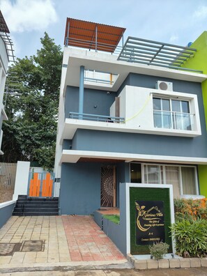 Un bâtiment moderne à deux étages, doté d’un toit plat, d’un balcon et d’une enseigne.
