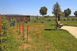 A park with a wooden bench, a playground with colorful equipment, and a clear sky. - Apartment in Vada Near Restaurants (Rosignano Marittimo)