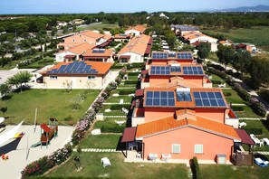 A residential area with houses featuring solar panels and a playground. - Apartment in Vada Near Restaurants (Rosignano Marittimo)