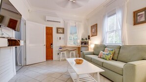 A compact living space with a kitchenette, a green sofa, a white coffee table, and a dining area with two chairs. - Harbor Walk Hideaways | Group Compound In Old Town, Pool! (Key West)