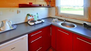 A compact kitchen with a built-in stove, a sink, and a dishwasher. - Comfortable Bungalows With a Fireplace and Terrace, Jaroslawiec (Postomino)