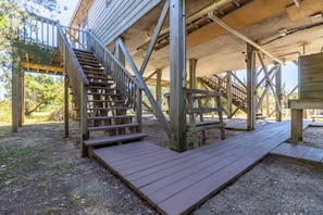 Sturdy wooden staircase leads to a covered deck area with a ramp for accessibility.