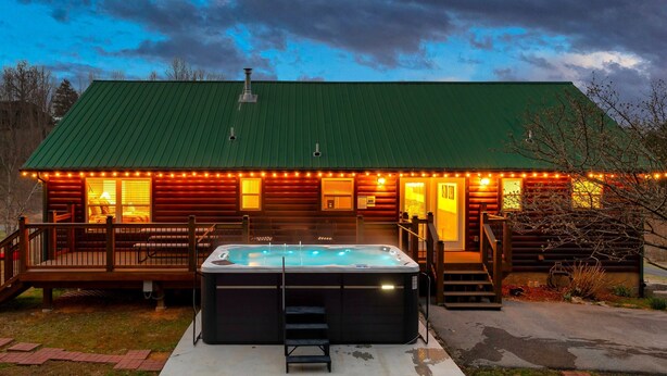 Une cabane dotée d’un bain à remous, d’une terrasse en bois et d’un toit végétalisé.