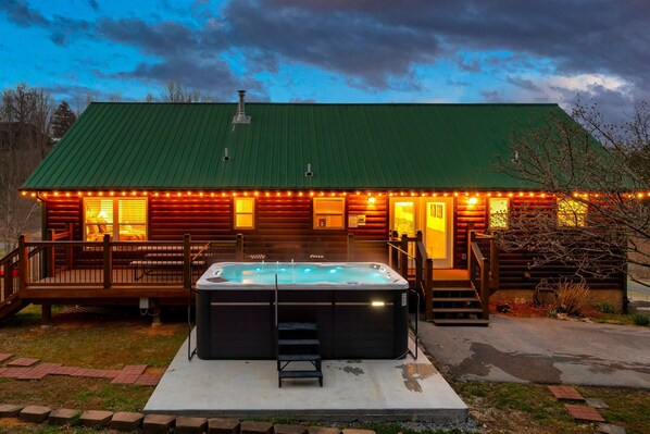 Une cabane dotée d’un bain à remous, d’une terrasse en bois et d’un toit végétalisé.