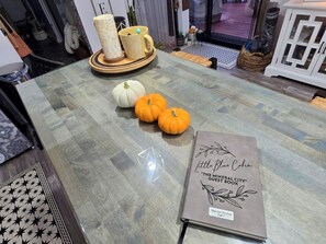 A table with a book titled 'Little Blue Cabin' and decorative pumpkins. - Boho Mtn Vibe'z~ Hot Tub+Fire Pit~ 3 mins to BRP! (Spruce Pine)