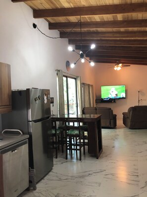 A compact living space with a kitchen area, dining table, and seating. - Playa Guiones/ Nosara (Nosara / Playa Guiones)