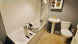 Een badkamer met een bad, een wastafel en een toilet.
