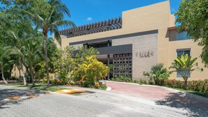A modern building with a flat roof and a large entrance. - Vaiven 124 - 2 Recamaras 4 Piscinas (Playa del Carmen)