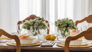 Mesa de comedor decorada con cristalería, platos y un centro de flores.