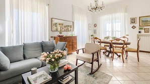 Una sala de estar con sofá, mesa de centro y comedor con sillas y mesa.
