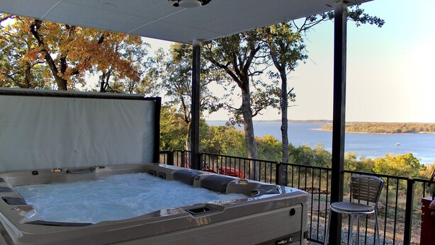 A hot tub with a view of a lake and trees.