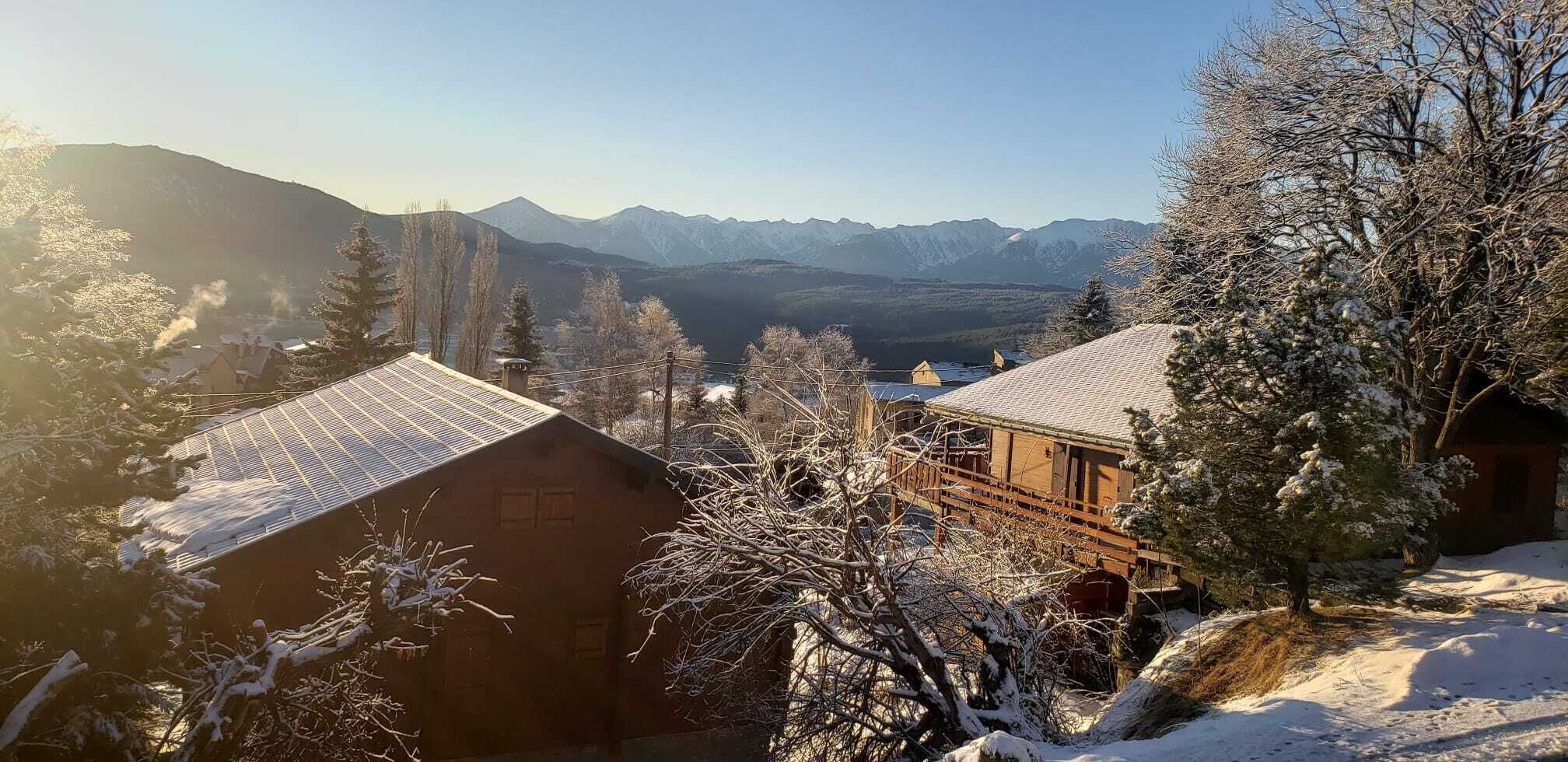 A snow-covered mountain landscape with buildings in the foreground.