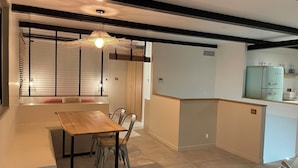 Une cuisine moderne dotée d’un réfrigérateur encastré, d’une table à manger en bois et de chaises.