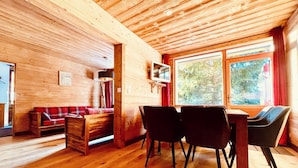 A wooden interior with a sofa, chairs, a table, and a TV. - Chalet Alpe One 1850 M - Alpe d'Huez (Huez)
