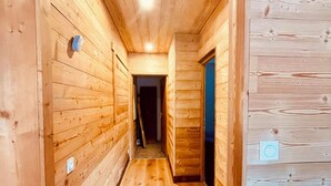 A wooden hallway with a wooden floor and walls, leading to a dark room at the end. - Chalet Alpe One 1850 M - Alpe d'Huez (Huez)
