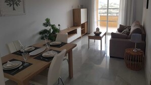 Un salon moderne comprenant un coin repas, un canapé et un téléviseur.