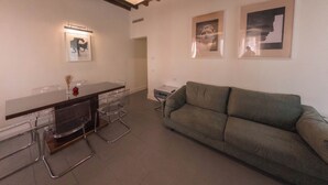Un interior moderno con zona de comedor, sofá y obras de arte en las paredes.