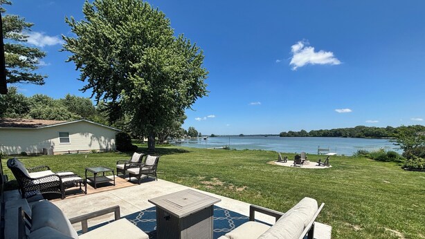 A backyard with a patio, outdoor furniture, a pool, and a view of a lake. - Modern Lake Home: Family Fun & Memorable Getaway! (Beaver Dam)