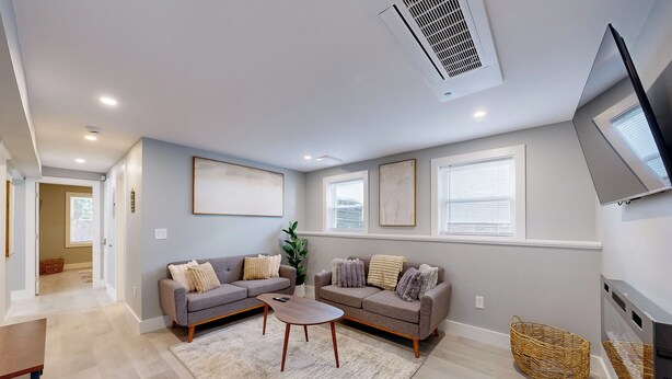 A modern living room with two sofas, a coffee table, and a TV. - Five75 Lux PROV - Suite 3  (Providence)