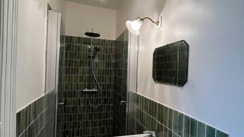 A bathroom with a shower, a sink, and a toilet.