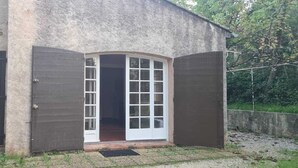 Ein rustikales Gebäude mit einer großen Holztür und einem kleineren Fenster.
