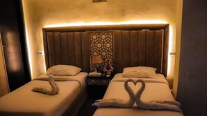 Ett hotellrum med två sängar, där varje säng har en handduk som är vikt till formen av en svan.