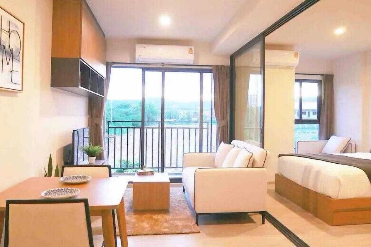 Una moderna camera d'hotel con balcone, divano, letto e zona pranzo.