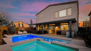 A modern house with a swimming pool, outdoor seating, and a covered patio. - Cozy Modern 5bd Home, 10mins to Airport, 15mins to the Strip, Pool & Jacuzzi! (Las Vegas)