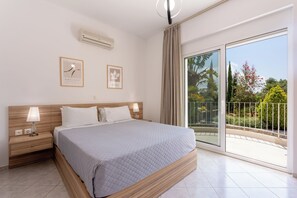 Un dormitorio moderno con una cama grande, lámparas de noche, una lámpara de techo y vistas al exterior a través de un ventanal corredero.