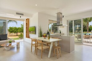 Una cocina moderna con comedor, ventanas amplias y vistas al exterior.