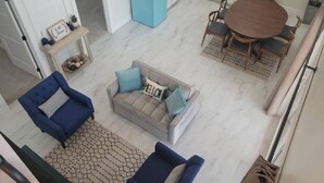 A spacious living area with a sofa, two armchairs, a dining table with chairs, a kitchen with a blue refrigerator, and a small side table with decorative items. - New, full Casita in North Phoenix with AC, WiFi (Phoenix)