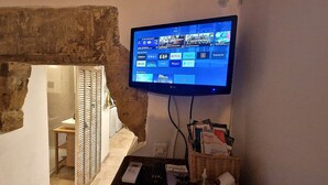 Seinälle asennettu televisio, jossa näkyy eri suoratoistopalveluiden sisältöä.