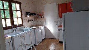 A kitchen with white cabinets, a sink, a stove, and a refrigerator. - Very quiet country house (Les Monts du Roumois)